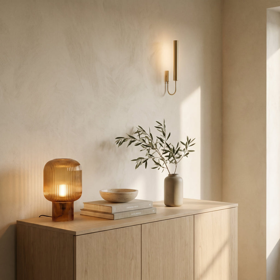 Brass and wood glass table lamp casting warm light on a side table